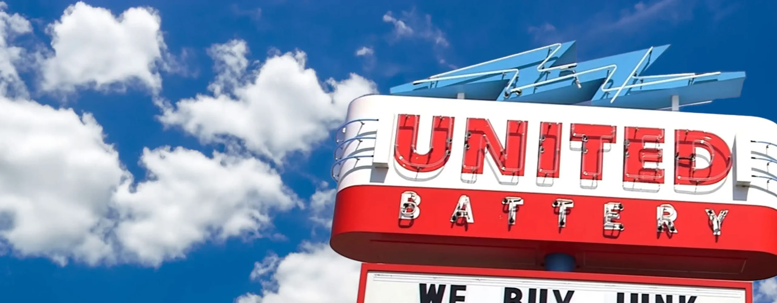 The neon United Battery sign above their storefront.