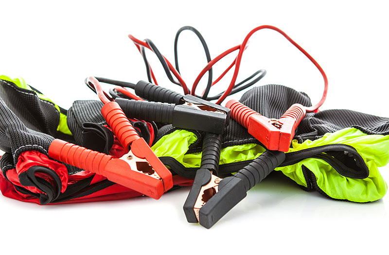 an image showing jumper cables on top of neon green and red gloves