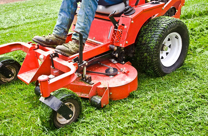 an image of a person using a ridable lawn mower