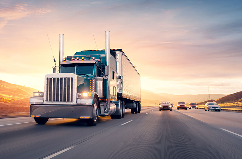 an image of a highway filled with vehicles, with the focus on a semi-trailer