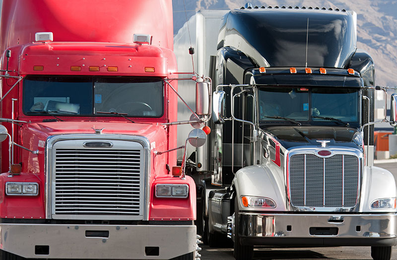 an image of two semi-trailers next to each other on the road