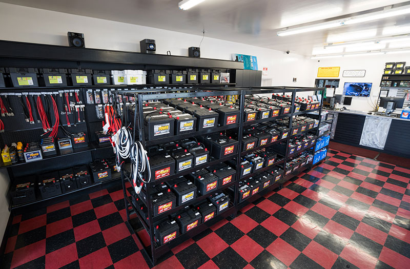 an image showing United Battery's shop with stands of batteries, cables, and maintainers