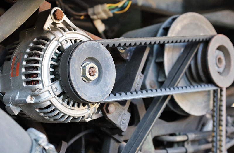 An alternator in a car engine bay.