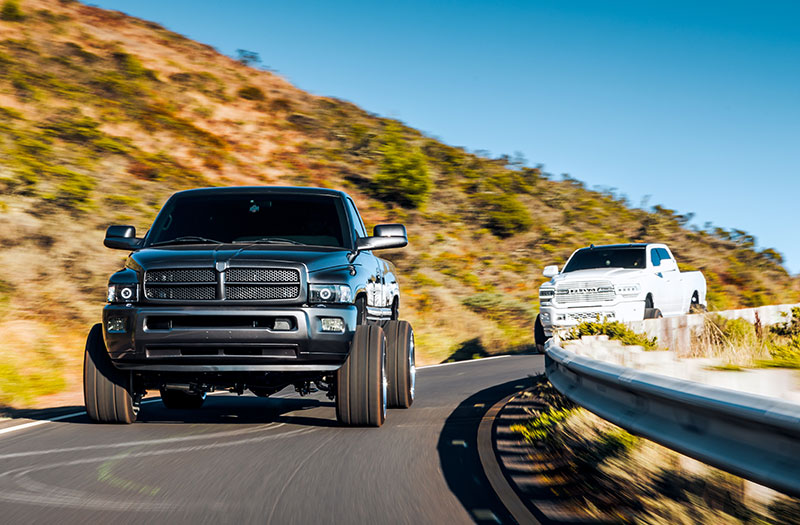 An action shot of two full-size pickup trucks driving around a corner.