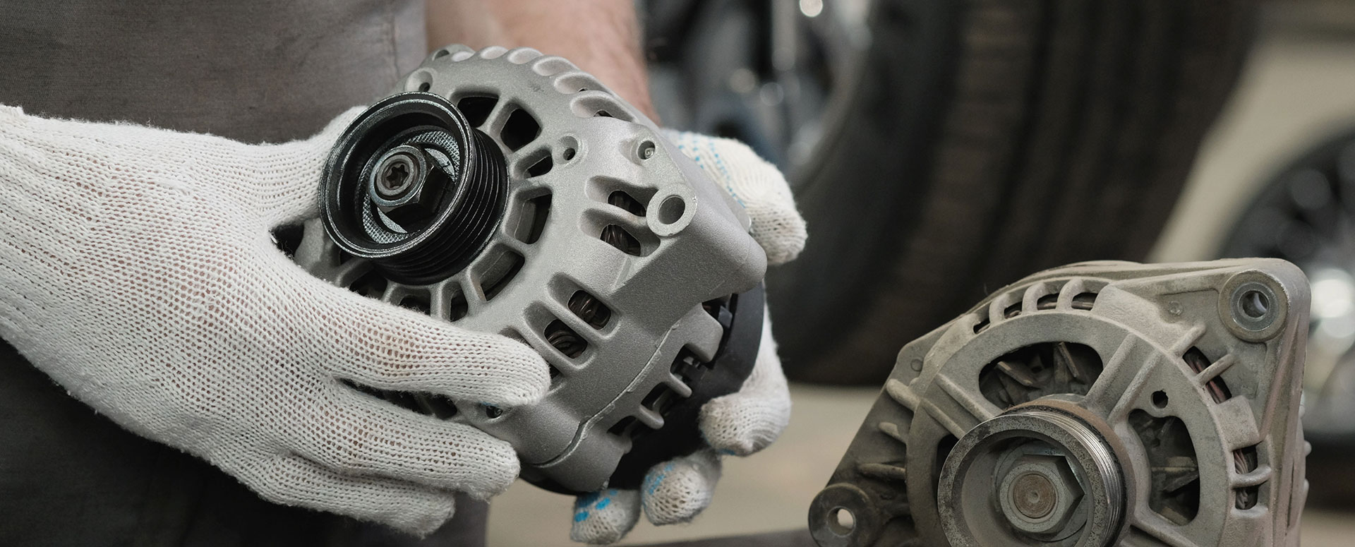 A technician handles a rebuilt alternator.