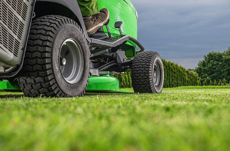 A ride-on mower cutting grass on a lawn.